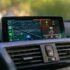 Car dashboard displaying navigation and music apps.