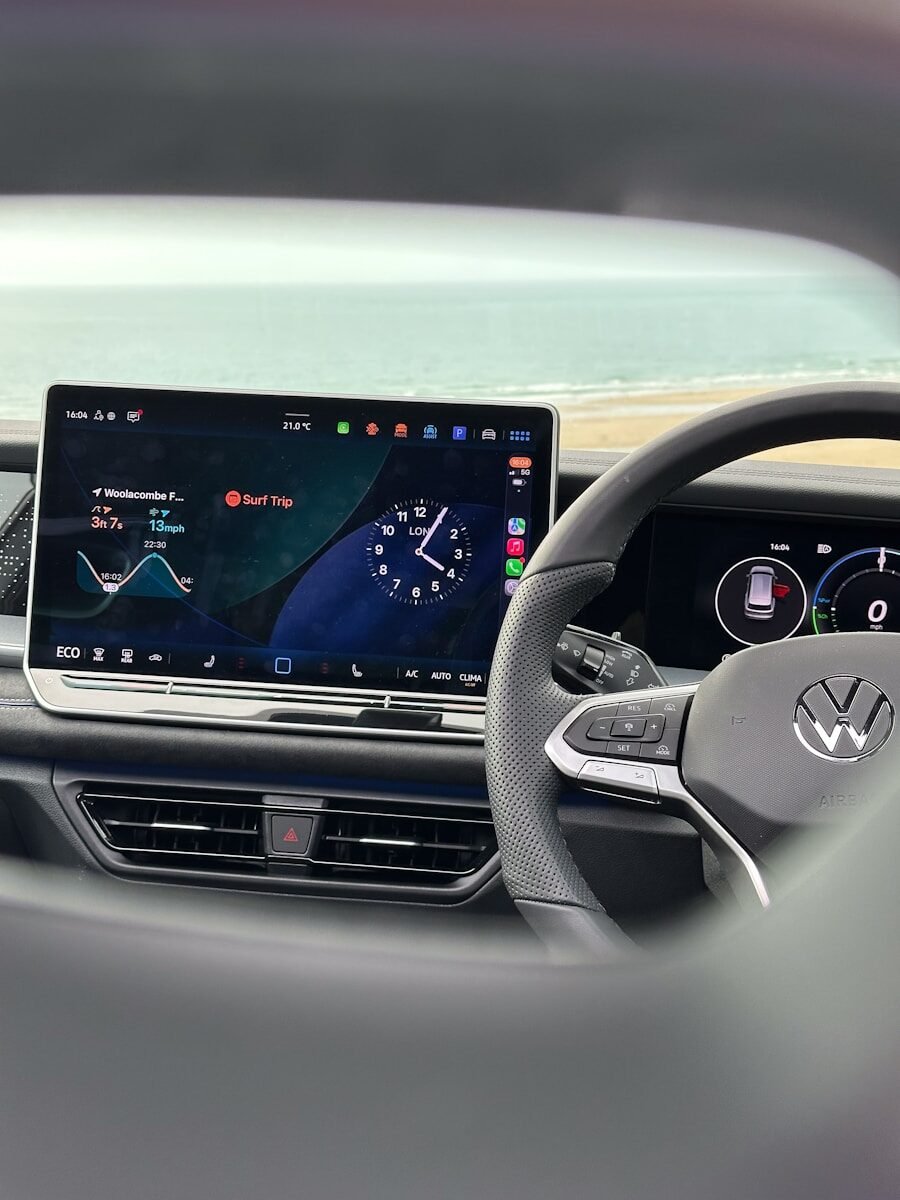 Modern car dashboard with digital display and steering wheel.
