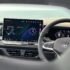 Modern car dashboard with digital display and steering wheel.